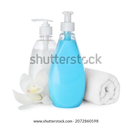 Dispensers of liquid soap, rolled towel and orchid flower on white background