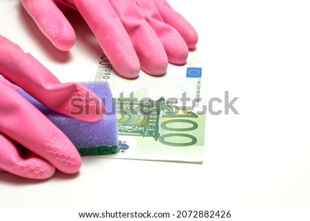 Money laundering in offshore and criminal capitals. The concept of anti laundering money ALM. 100 (hundred) euro, glowes and dishwash in a white background. High quality photo Royalty-Free Stock Photo #2072882426