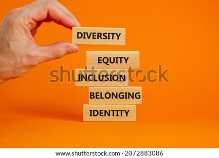 Diversity, equity, inclusion, belonging, identity symbol. Wooden blocks with words Diversity, equity, inclusion, belonging, identity on beautiful orange background. Business, Inclusion concept.
