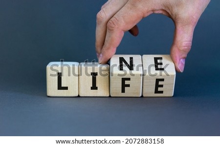 Lifeline, line of life symbol. Businessman hand turns cubes and changes the word 'life' to 'line'. Beautiful grey background. Business lifeline, line of life concept. Copy space.