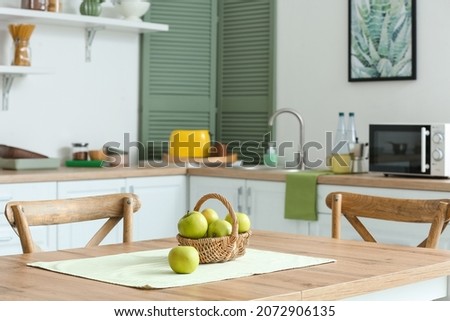 Dining table with apples in interior of modern kitchen