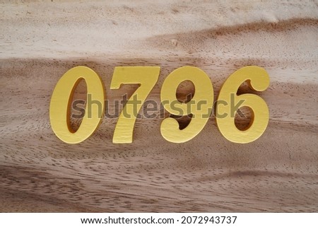 Golden Arabic numerals 0796 on a dark brown to white wood grain background.