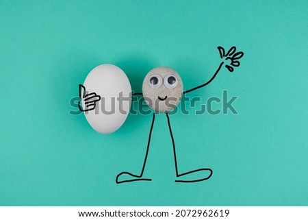 Animated pebble with a happy face, greeting all and holds one clear white egg on blue paper background. Heppy easter