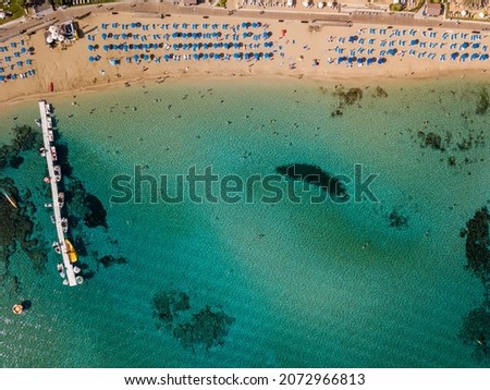 Aerial view of sun loungers on beach with clear sea