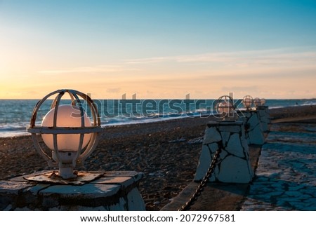 round lighting lamp on the embankment. an old lamp to illuminate a promenade on the sea. skyline and sunset