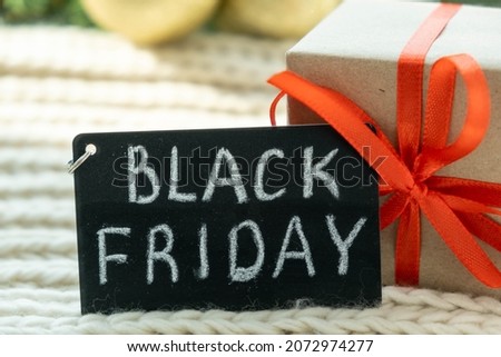 Promotional sign of black Friday and gift box on the Christmas background. Black friday design, super sale, discount, advertising, marketing price tag.