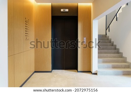 Elevator in the lobby hall of an apartment building. Modern decor and wood finishing of the ground floor and entrance. Royalty-Free Stock Photo #2072975156