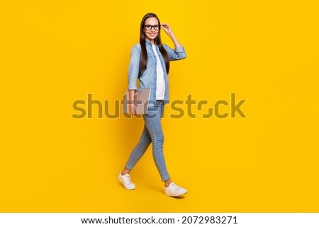 Full size profile side photo of young pretty woman go walk eyewear confident smart agent isolated over yellow color background