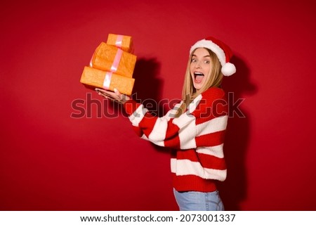 A girl insanta hat carrying lots of gift boxes