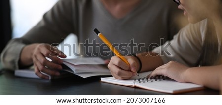 Female private tutor helping young student doing homework . Tutorial and educational concept. Royalty-Free Stock Photo #2073007166
