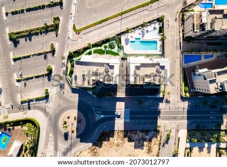 Aerial drone point of view high rise residential buildings district of Mil Palmeras, well-groomed parking lot, empty streets and crossroads view from top. Costa Blanca, Province of Alicante. Spain