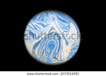 Multicolor psychedelic abstract round blue planet in universe. Closeup soap bubble like an alien planet on dark background