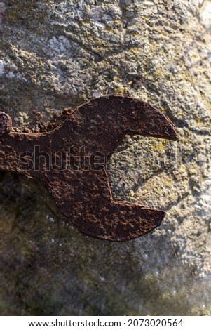 Rusty wrench on stone. Old wrench
