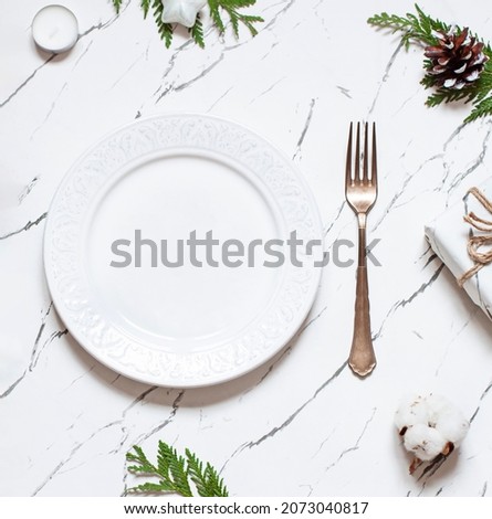 Christmas or New Year table settings on the marble texture table with festive decoration. Top view. Copy space	