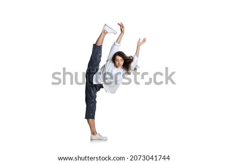 Flexible woman in casual wear standing in a twine isolated on white background. Graceful female ballet, contemporary dancer weightless moves. Art, motion, action, flexibility, inspiration concept