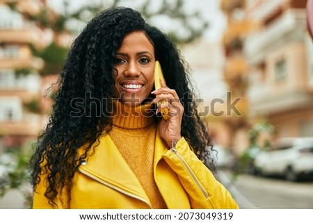 Middle age african american woman talking on the smartphone at the city.