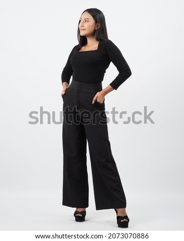 Asian woman full body. Thai woman in a modern chic style stands in white studio with elegant and confident pose. Casting model supporting actor actress. Asian woman fullbody pose in front of camera. Royalty-Free Stock Photo #2073070886