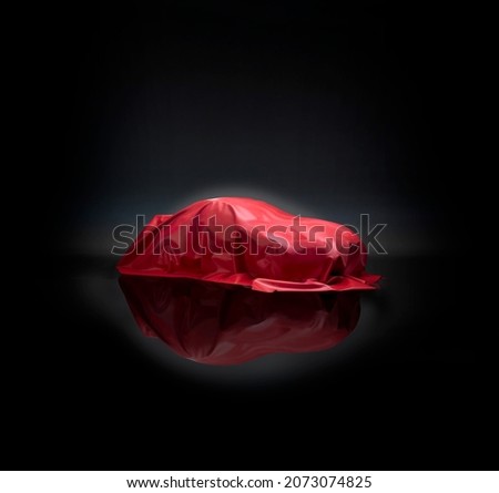 Car covered in red cloth, ready for reveal, concept car, motor show Royalty-Free Stock Photo #2073074825