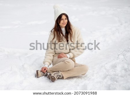 Portrait of a beautiful European woman in a winter forest, the woman has long hair, celebrating Christmas and New Year.
