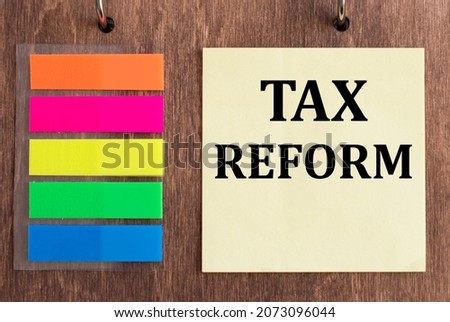 Tax Reform on a yellow sticker on a wooden background. Business concept for Government Change in Taxes written on sticky note paper on the wooden background.