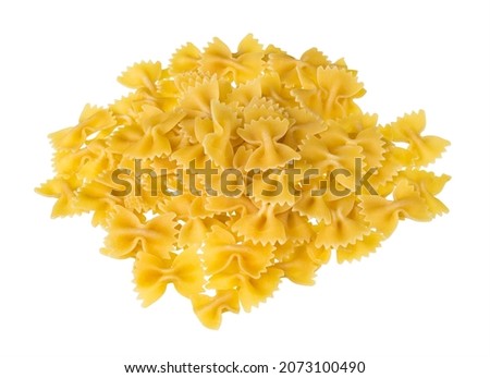 Heap of dry eggless farfalle pasta isolated on a white background. Closeup of spilled yellow bow-tie pastas pile from wheat semolina. Butterfly shaped meal with saccharides, starch and gluten content. Royalty-Free Stock Photo #2073100490