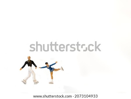 miniature figures ice skaters couple isolated on white background. copy space