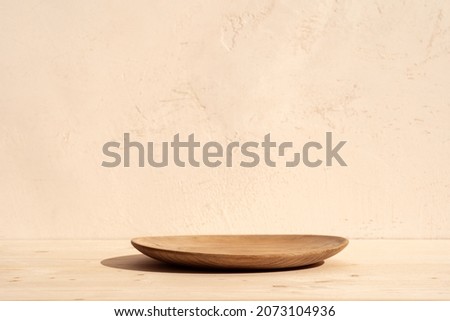 Round wooden podium for food, products or cosmetics against bright brown background.
