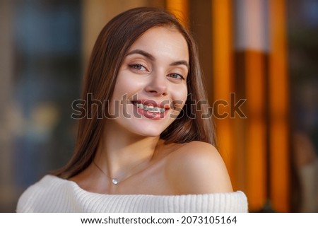 portrait of a beautiful happy smiling young woman with braces. Attractive girl with bracket system posing in city outdoor. Brace, bracket, dental care, malocclusion, orthodontic health concept. Blurre Royalty-Free Stock Photo #2073105164