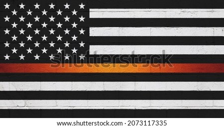 The American flag painted on a brick wall in Black and white with a orange stripe.