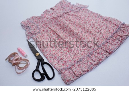 Sewing accessories and fabric on wooden background.