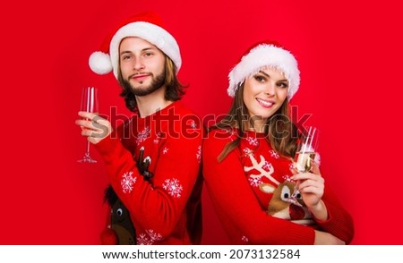 Beautiful couple in Santa hats with champagne. Family Holidays. Merry Christmas and happy New Year. Relationships.
