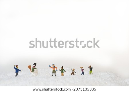 playing miniature figures Children in a snow landscape with a snowman. White background . copy space
