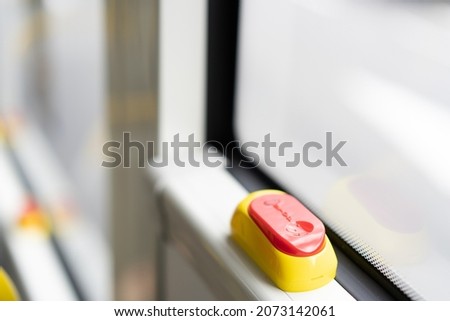 A close up of the stop button in the interior of a bus used to alert the bus driver that you would like to get off at the next bus. 