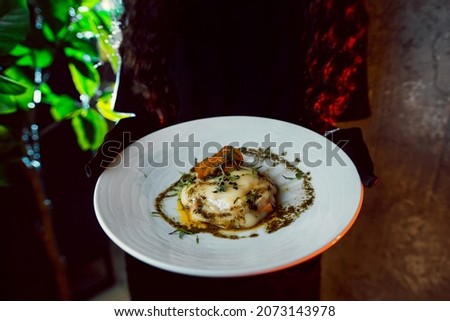 Mashed potatoes with red fish under baked cheese and aromatic sunflower oil with aromatic spices