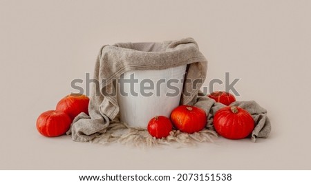 Tiny basin for newborn studio photoshoot decorated with pumpkins. Cute decoration for infant child kid photos