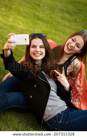 Two Young Women Taking A Self Portrait With Smartphone