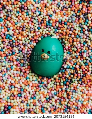 Funny image of a toy surrounded in colorful balls, smiling duck toy, party concept with copy space, happy day, invitation post card