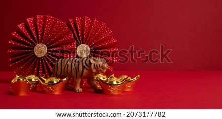 Chinese new year festival decoration over red background. Traditional lunar new year gold ingots, paper fans. Copy space, banner Royalty-Free Stock Photo #2073177782