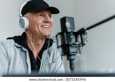 Workplace in the recording studio. The blogger is blogging communication with clients. The radio presenter transmits the news in the morning. An adult man speaks into the microphone.