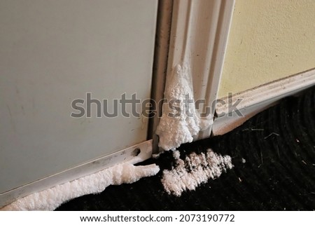 Closeup of a door covered in frost due to the cold Royalty-Free Stock Photo #2073190772