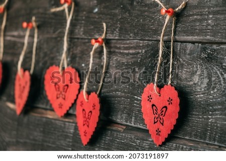 Wooden hearts on a thread. Close-ups of a doe hang on a wooden wall. Love and relationships