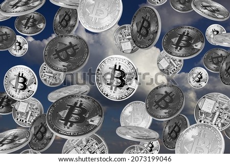 Falling bitcoins over blue sky