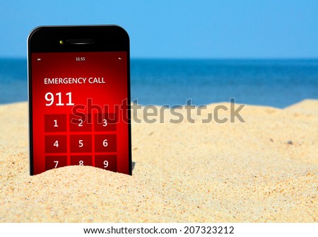 mobile phone with emergency number 911 on the beach. focus on screen