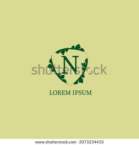 Letter N alphabetic logo design template isolated on green beige color. Decorative floral shield sign illustration. Nature Guard, Security logo concept. 