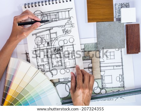 Architect /interior's hands drawing home illustration with material sample, renovation  concept