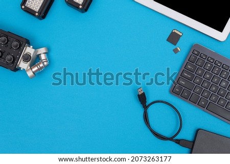 Top View of Photographer's, Videographer's or Video Blogger's Workplace. Digital Gadgets Lying on Blue Table - Flat Lay