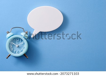 antique alarm clock with speech bubble  on blue background