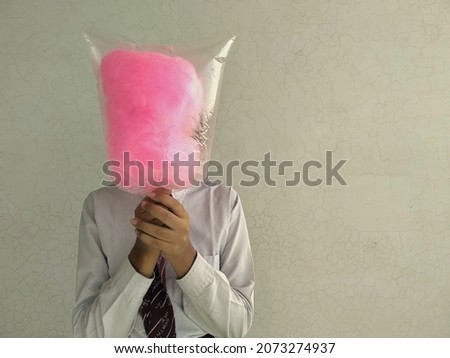 A school student with her face covered with cotton candy. School bullying concept. 