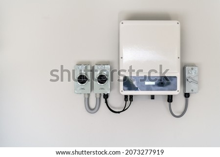 New solar panel inverter with isolators attached to the wall Royalty-Free Stock Photo #2073277919