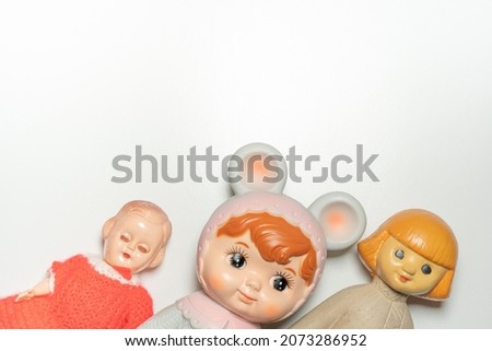 Top view close up or macro photography of colorful plastic collection of antique, vintage or retro childhood treasures old school toys and dolls 50s 60s mid century with white copy space background